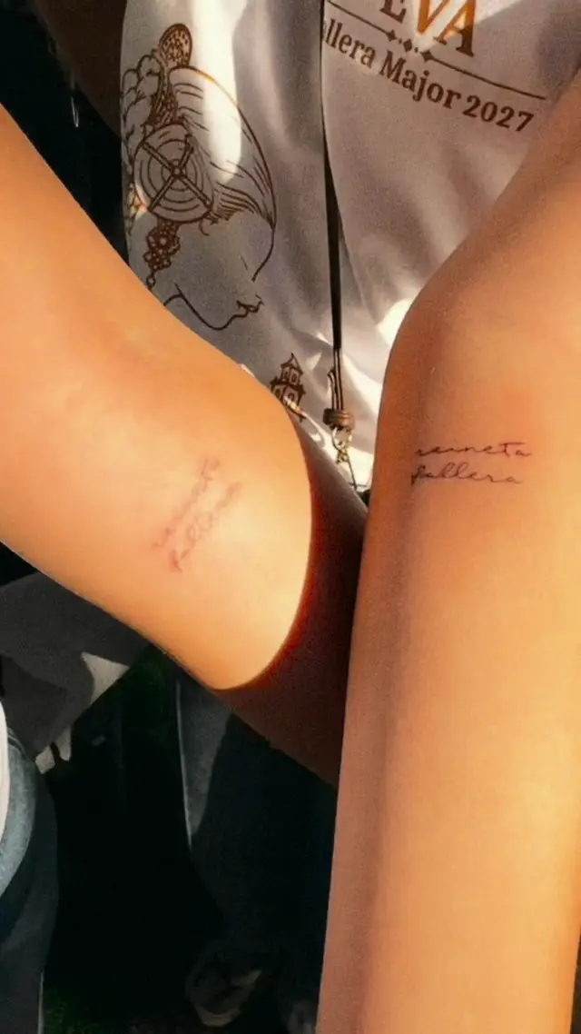 Open-air mini tattoos at a town festival: falleras showing their fresh tattoos and Alba tattooing at the table